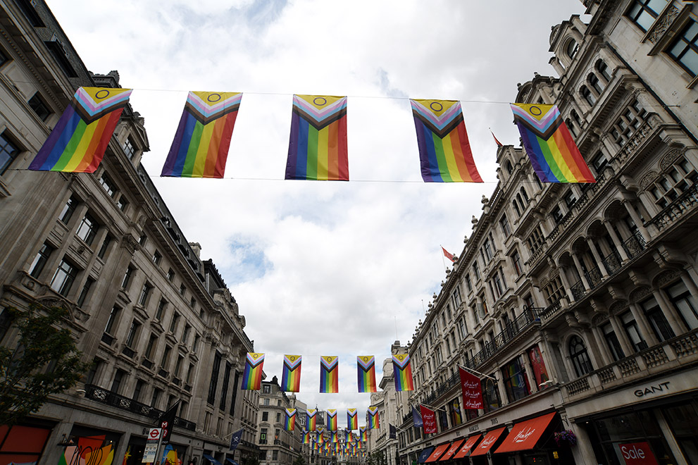 a shot looking up at pride flags hanging across a road in london